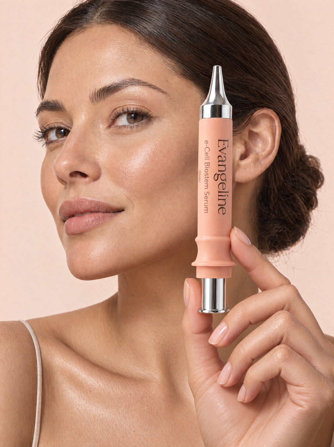 Woman holding Evangeline e-Cell Biostem Serum syringe beside her cheek