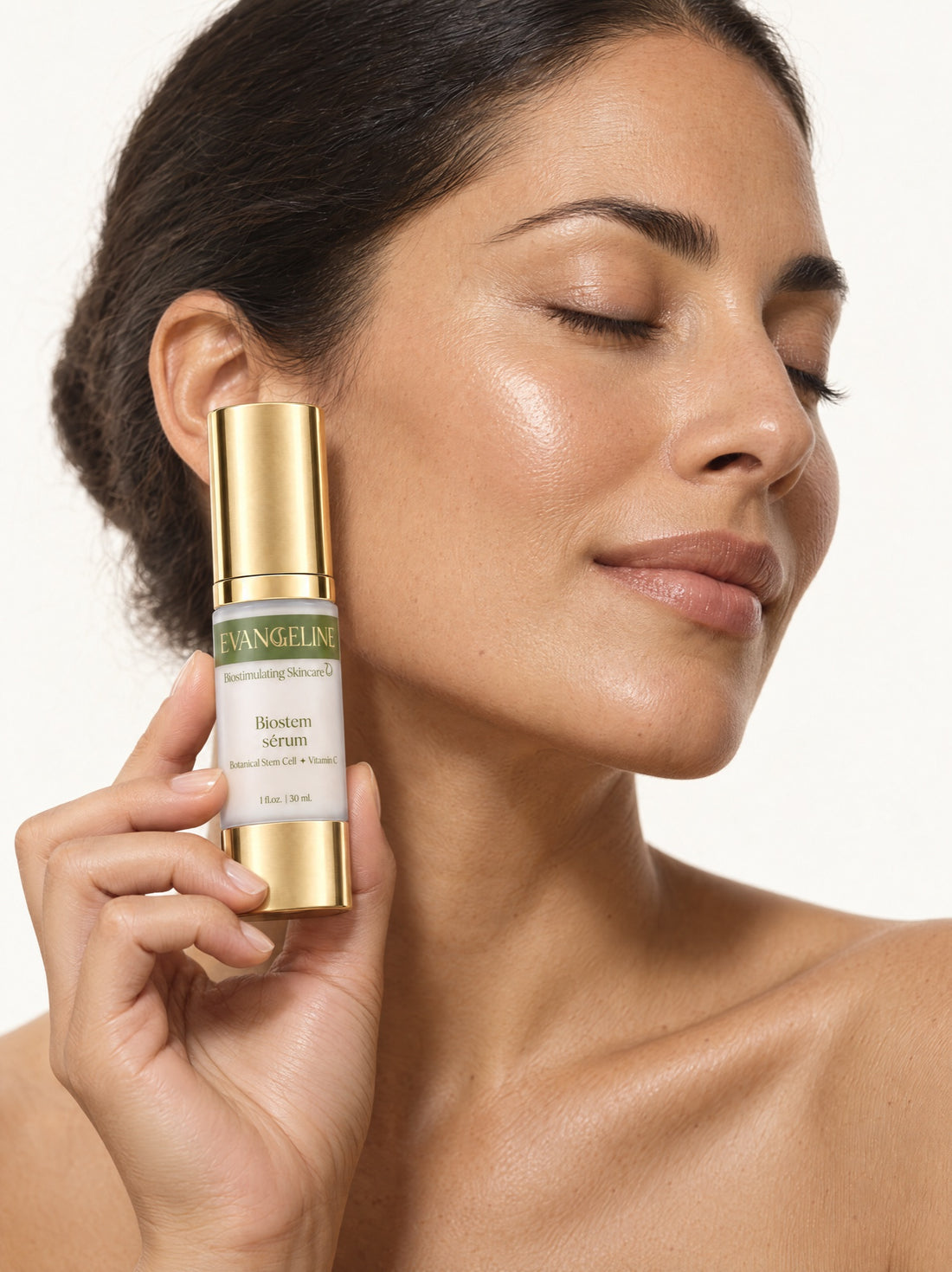 Woman holding Evangeline Biostem Serum beside her cheek