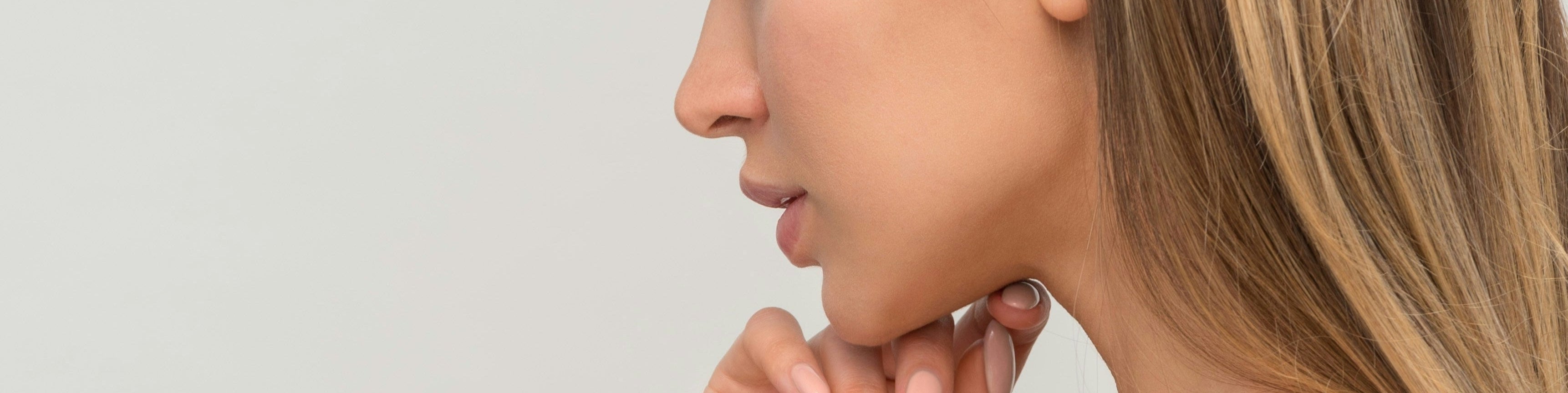 Woman's neck and shoulder with a neutral background